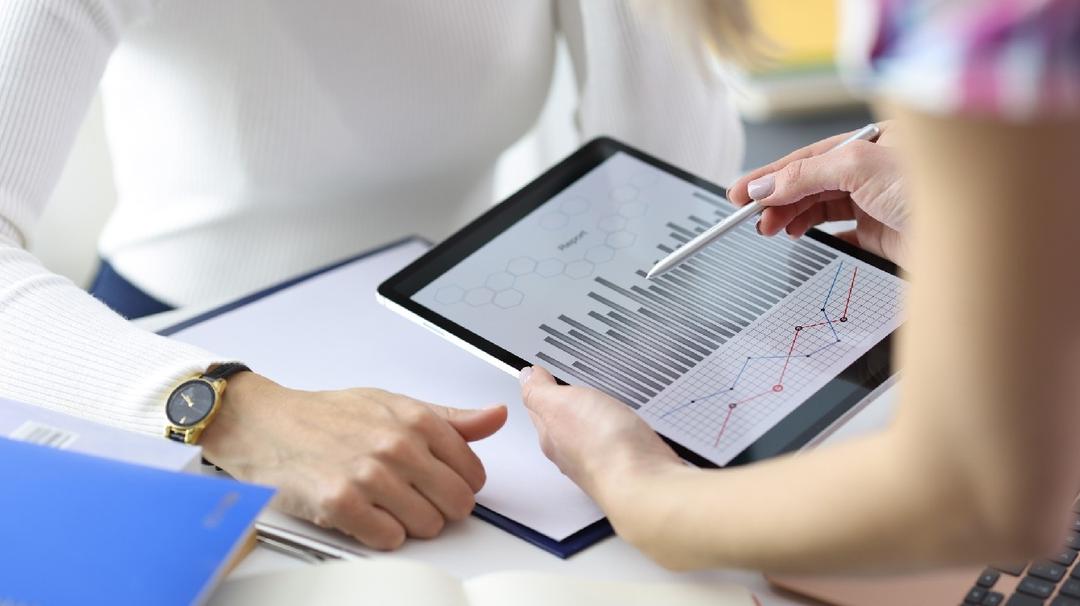 GoDaddy bookkeeping shuts down Businesswoman showing colleague graph on digital tablet closeup. Profit growth dynamics concept